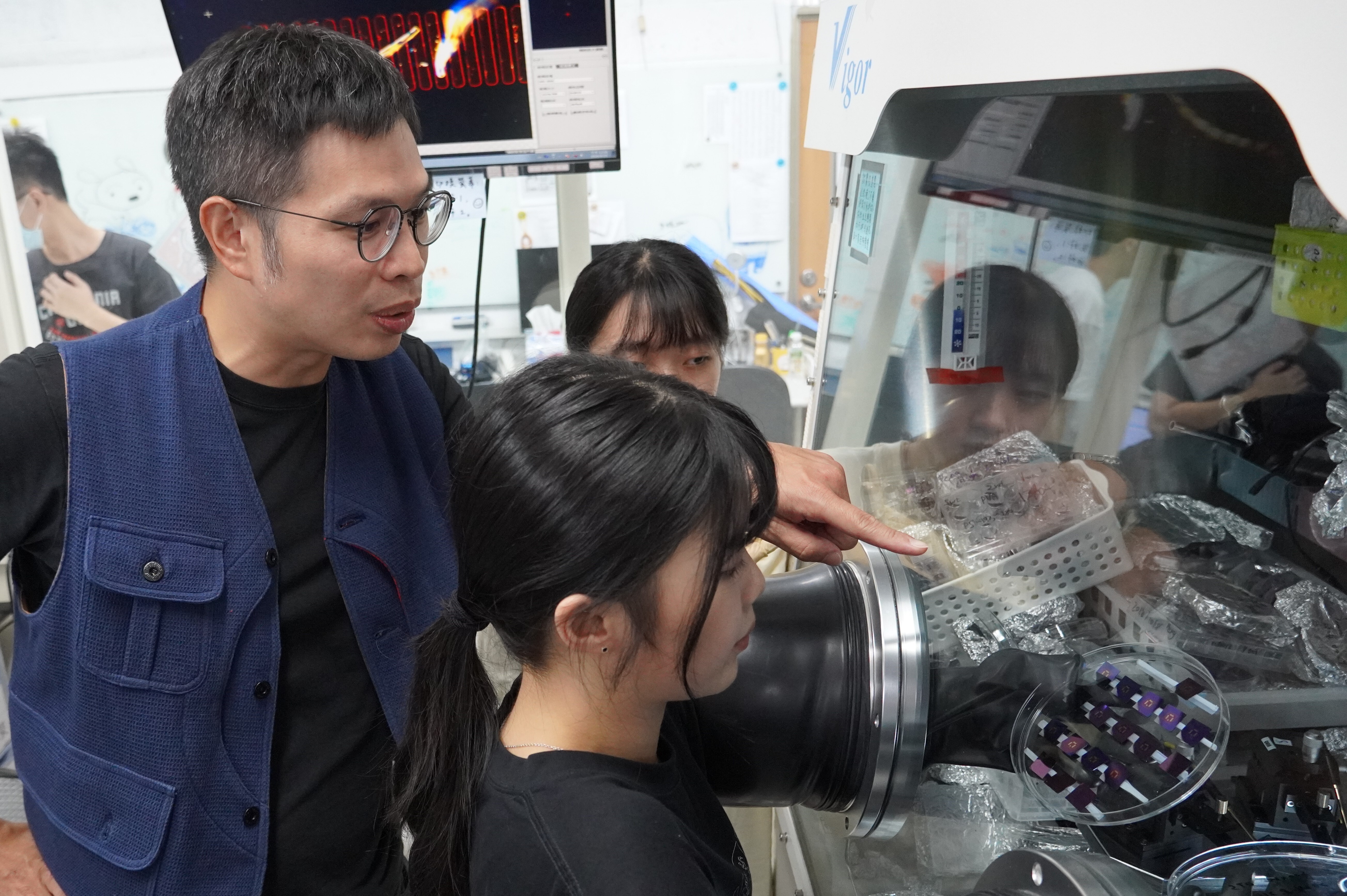 Associate Professor Yu-Cheng Chiu instructs students on the preparation and measurement of polymer transistors.