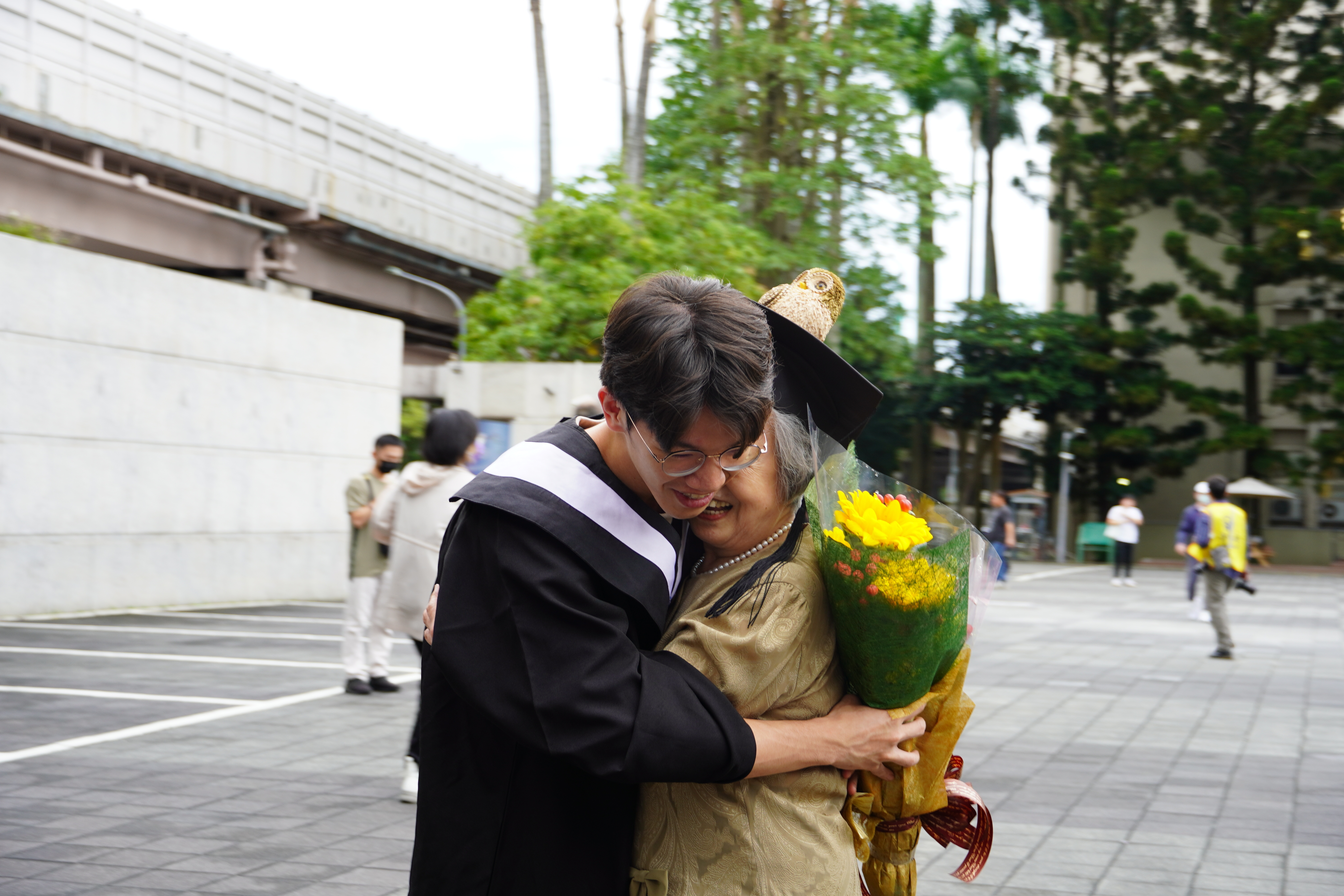 Grandma warmly embraces her grandson, wishing him a happy graduation.