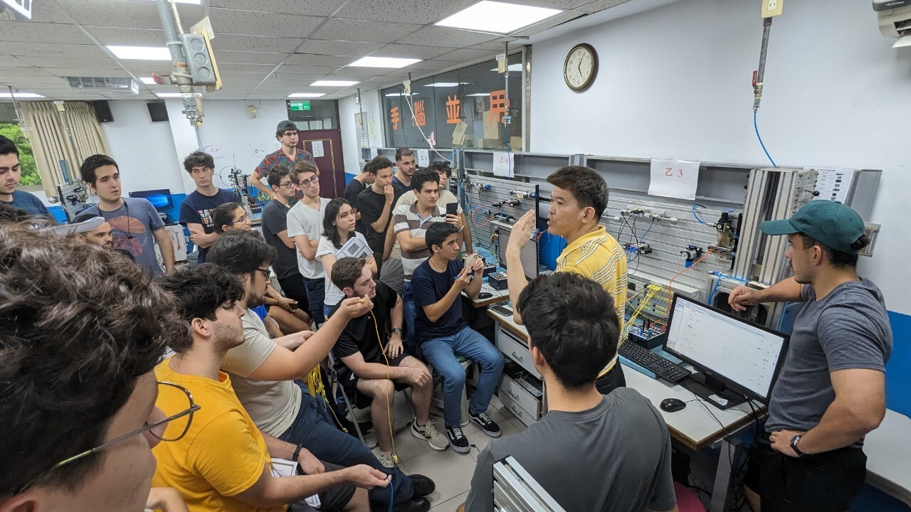 Professor Zhi-Hui Li leads students in operating a Programmable Logic Controller (PLC).