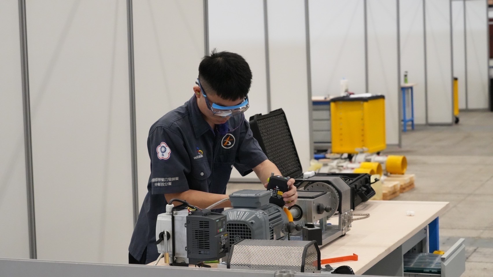 Chia-Yo Chuang operates laser alignment simulation equipment to conduct data measurements.