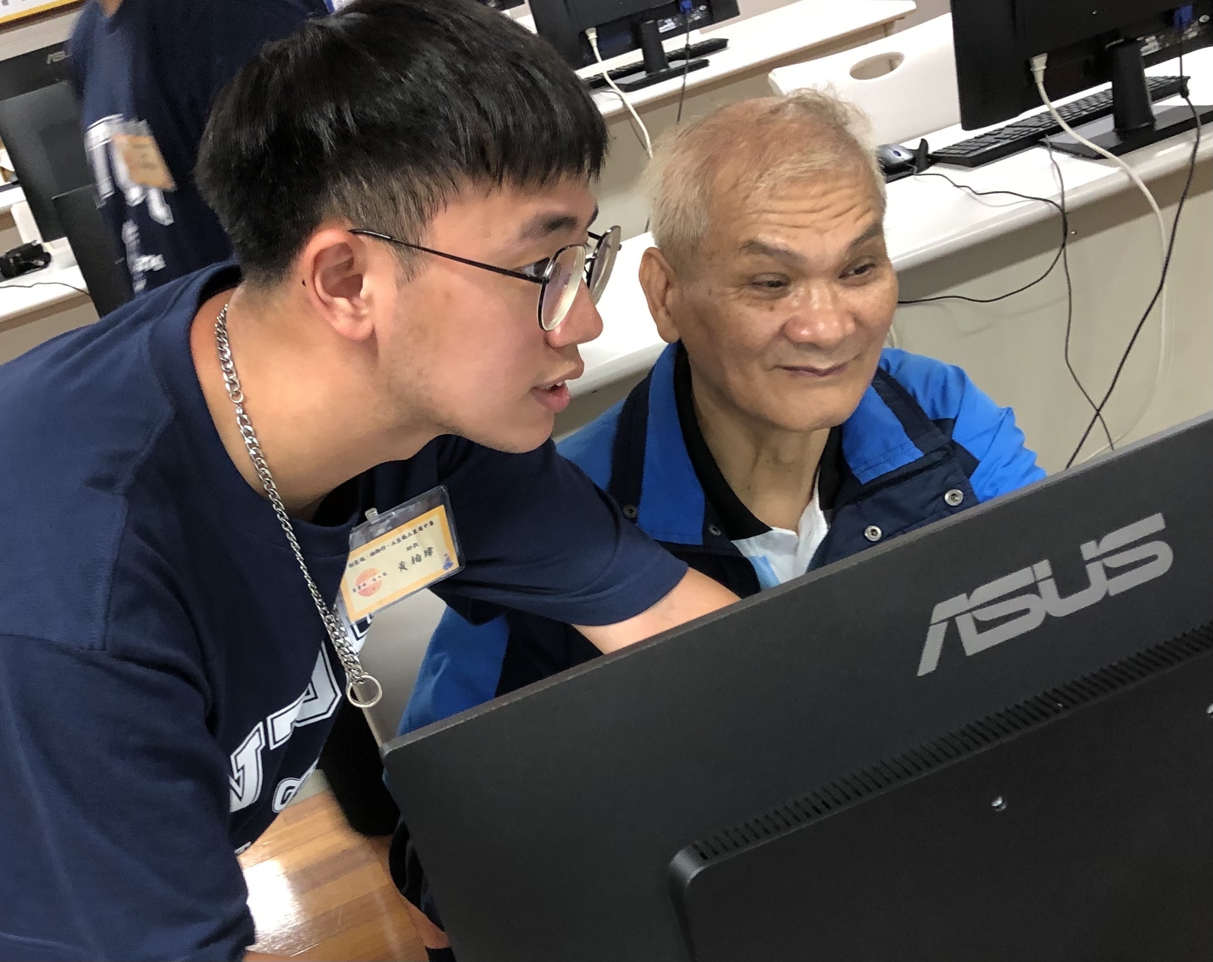 Teaching assistant Bo-Wei Huang (left) guides participants in computer graphic design.