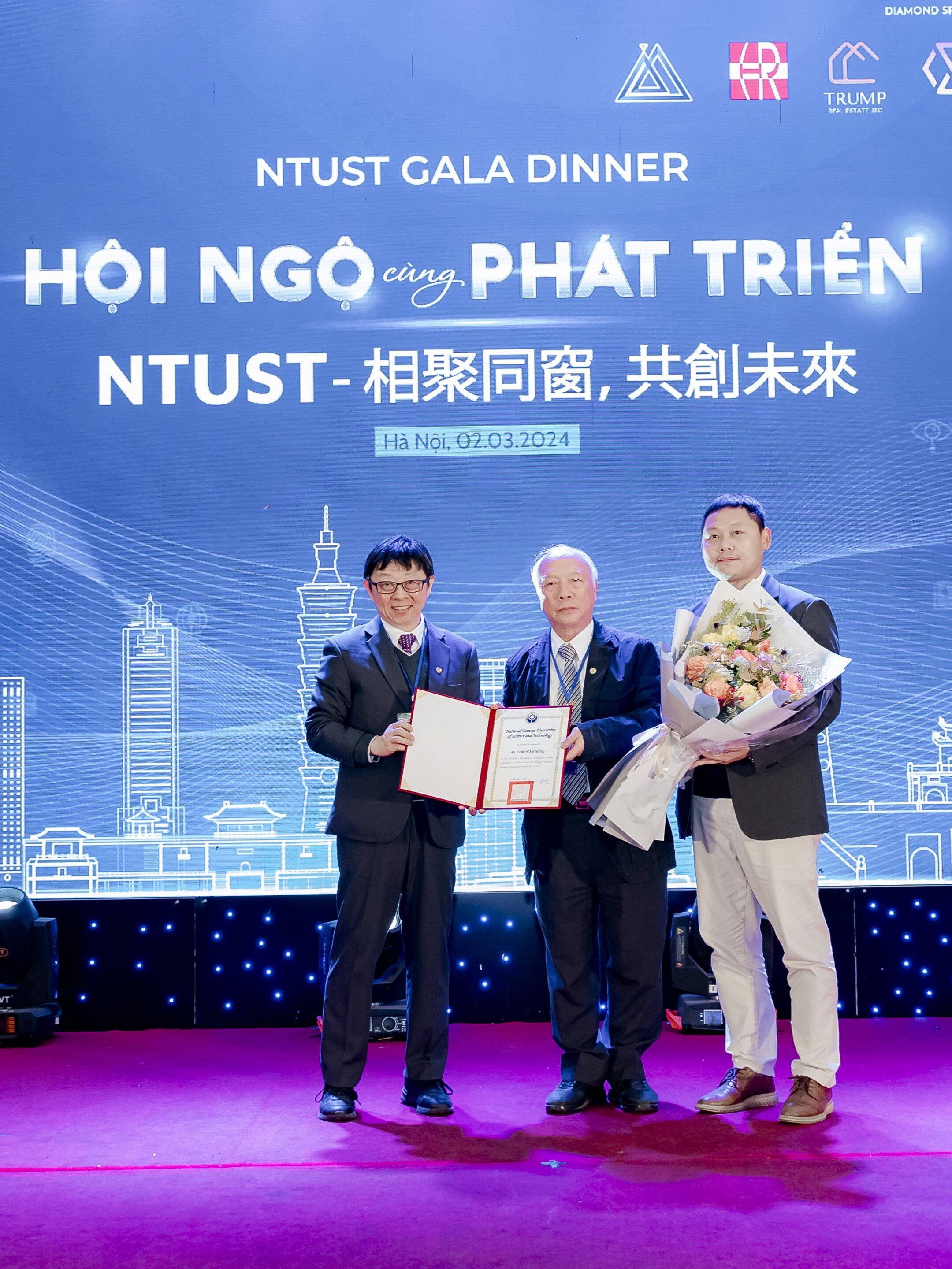 President Jia-Yush Yen (left) presents the Honorary President certificate to Alumni Han-Ming Liao (center) from the Department of Industrial Management, while the newly appointed President of the Vietnamese Alumni Association, Wen-Ning Yang (right), presents flowers in appreciation.