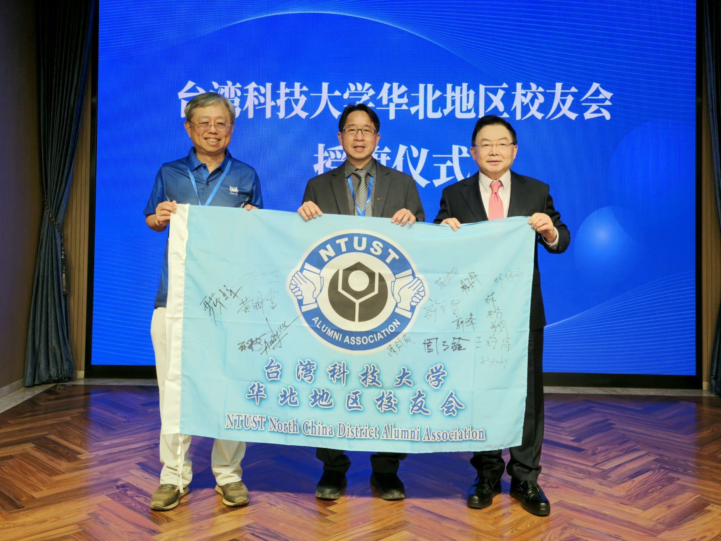 Vice President Tzu-Chuan Chou of Taiwan Tech (middle) and Chairman Jian-Wei Chen of the Alumni Association (left) jointly presented the flag to the North China District Alumni Association (with President Xi-Yuan Wu on the right).